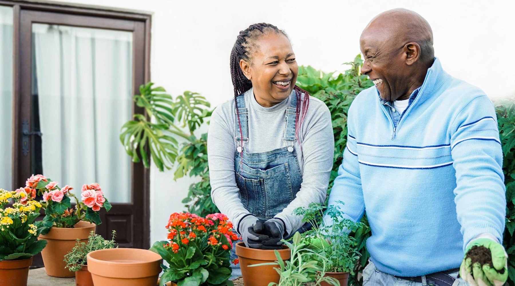 a man and a woman smiling while gardening